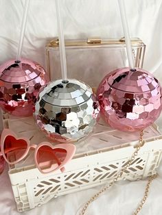 three shiny disco ball purses with heart shaped sunglasses