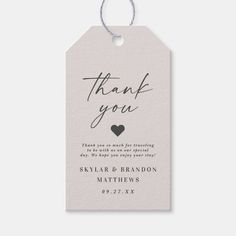 a thank card with the words thank you and a heart on it, hanging from a string