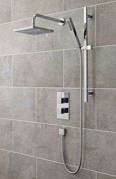 a shower head with thermostaer and hand held shower faucet in grey tile