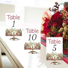 three place cards are placed next to each other on a table with red and green decorations