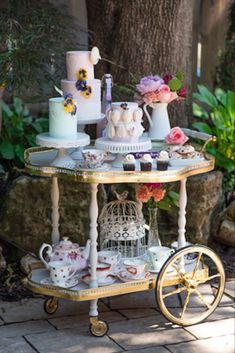 a table with cakes and tea cups on it