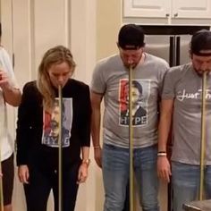 a group of people standing next to each other in front of a stove top oven