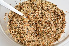 a bowl filled with bird seed mixture and a spoon