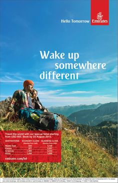 a man sitting on top of a grass covered hill next to a mountain with the words wake up somewhere different