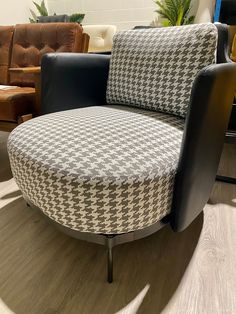 a black and white chair sitting on top of a wooden floor next to a couch