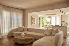 a living room filled with furniture next to a kitchen