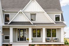 a white house with gray shingles and windows