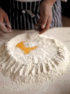 a person in an apron is kneading flour on a table