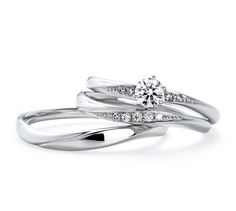 two white gold wedding rings with diamonds on each band and the center diamond in the middle