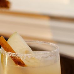 an apple cider cocktail with cinnamon garnish and sugar on the rim is ready to be eaten