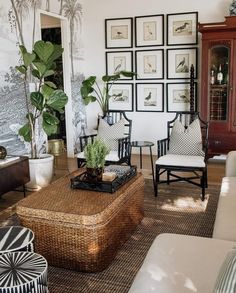 a living room filled with lots of furniture and pictures hanging on the wall above it