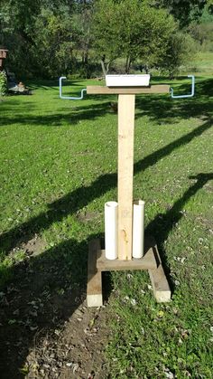 a wooden stand with two rolls of toilet paper on it in the middle of a field