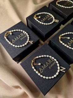 four personalized bracelets in black boxes with gold lettering on the front and bottom