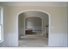 an empty room with white trim and beige walls