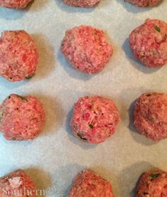 raw meatballs on a baking sheet ready to be cooked in the oven for consumption