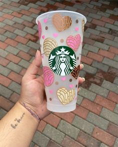 someone holding up a starbucks cup with hearts on it