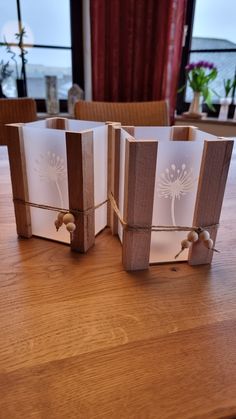 three small wooden boxes sitting on top of a table with string tied around the edges