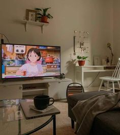 a flat screen tv sitting inside of a living room next to a table and chair