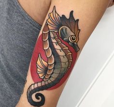 a woman's arm with a seahorse tattoo on it