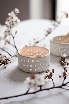 two white rings sitting on top of a table next to flowers and wooden spoons