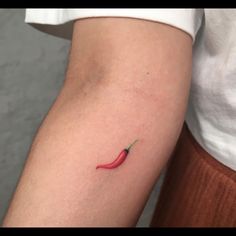 a small red chili pepper on the left arm and right leg, with a green tip