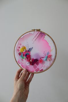 a hand is holding up a small embroidery kit