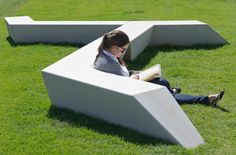 a woman sitting in the grass reading a book