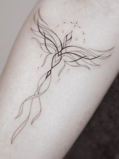 a woman's arm with a black and white tattoo design on the left forearm