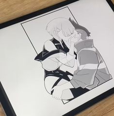 a drawing of an anime character is displayed on a wooden table next to a framed photo