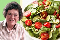 an older woman standing next to a plate of salad with tomatoes and cucumbers