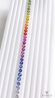 a rainbow colored beaded necklace on a white background