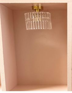 an empty shelf with a chandelier hanging from it's ceiling in the corner