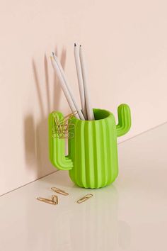 a green cup with toothbrushes sticking out of it