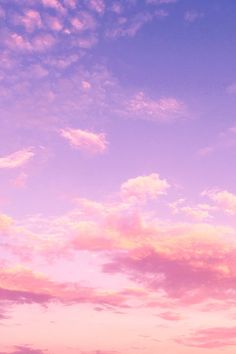 an airplane is flying in the sky with pink and blue clouds behind it at sunset