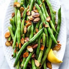 asparagus with almonds and lemon on a white plate