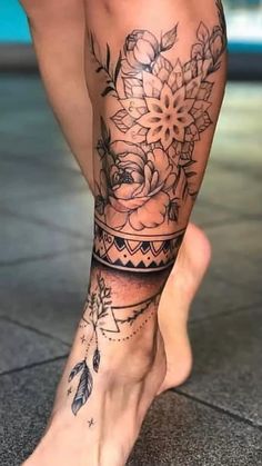 a woman's legs with tattoos and flowers on her leg, in front of a tiled floor