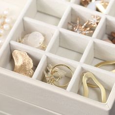 an open white box filled with lots of jewelry