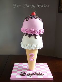 a cake shaped like an ice cream cone on top of a checkerboard table