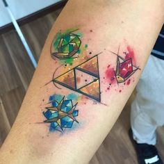 a colorful tattoo on the arm of a man with geometric shapes and colors around it