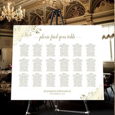 a white table plan sitting on top of a easel in front of a chandelier