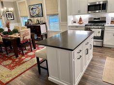 a kitchen with white cabinets and an island in front of a stove top oven next to a dining room table