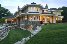 a large house with lots of windows on the front and side of it at night