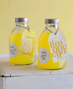 two jars with labels on them sitting next to each other