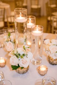 the table is set with white flowers and candles