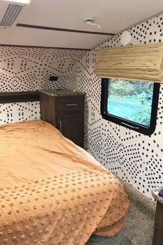 a bedroom with a bed, dresser and tv in the back wall is decorated with black dots