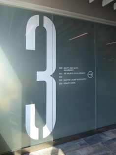 the number 3 is etched on glass to give it an interesting look in this building's entrance