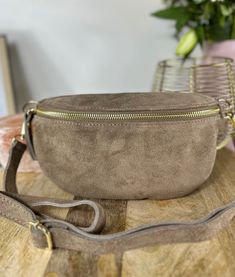 Suede Cowhide Leather Belt Bag 23x14 cm with Adjustable Shoulder Strap Welcome to the world of practical elegance with our premium suede cowhide fanny pack. This bag, with its perfect dimensions of 23*14 cm, embodies the perfect marriage between functionality and style. Made from suede cowhide, this fanny pack offers a luxurious texture and exceptional durability. The adjustable shoulder strap guarantees a perfect fit, allowing this companion to adapt to all styles and body shapes. The interior Leather Belt Bag With Zipper Closure In Beige, Beige Leather Belt Bag With Zipper Closure, The Perfect Marriage, Leather Fanny Pack, Leather Belt Bag, Sling Bags, Perfect Marriage, Clever Design, Welcome To The World