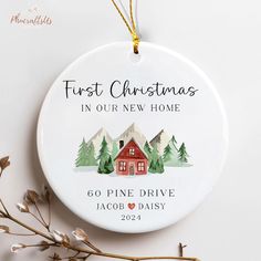 a christmas ornament with a house and trees on it