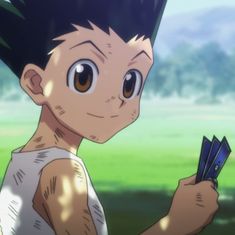 a young boy holding up some cards in his hand