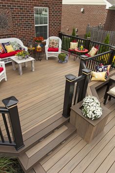 a wooden deck with chairs and pillows on it